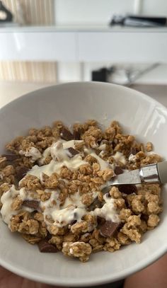 a person is holding a bowl of cereal