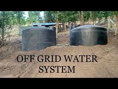 two large black tanks sitting on top of dirt