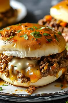 two cheeseburger sandwiches on a plate with meat and gravy toppings