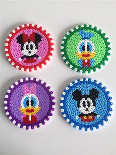 four round beaded coasters with different designs on them