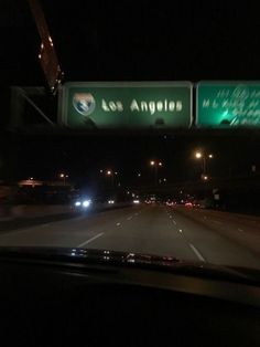 an exit sign is lit up at night on the freeway in los angeles, california