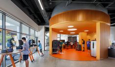 people are standing in an office with orange walls