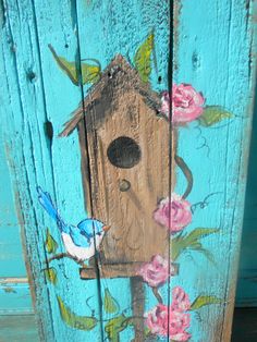 a birdhouse painted on the side of a wooden door