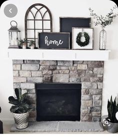 a living room with a fire place and some plants on top of the mantel