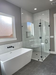 a white bath tub sitting inside of a bathroom next to a walk - in shower