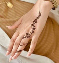 a woman's hand with a flower tattoo on her left wrist and the ring finger