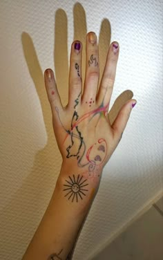 a woman's hand with tattoos on it