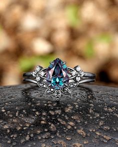 a ring with a blue topazte surrounded by white gold and diamonds on a rock