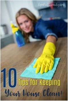 a woman cleaning a wooden table with yellow gloves on it and the words 10 tips for keeping your house clean