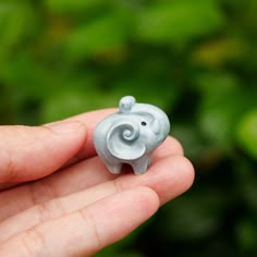 a small elephant figurine sitting in someone's hand