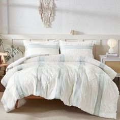 a bed with white and blue comforters in a bedroom