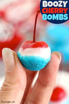 a hand holding up a cherry bomb with blue and white sprinkles on it