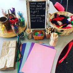 a table topped with lots of crafting supplies and a chalkboard on top of it