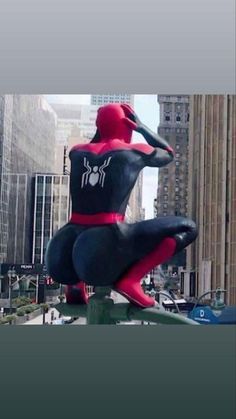 a giant spider man statue sitting on top of a building