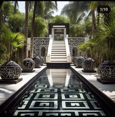 an outdoor swimming pool in the middle of palm trees and stairs leading up to it