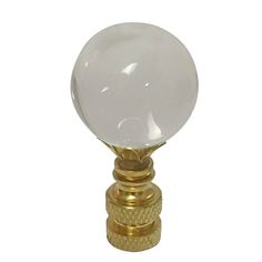 a white glass ball on a brass base