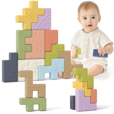 a baby sitting on the ground with blocks in front of him