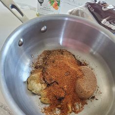 a metal bowl filled with spices on top of a counter