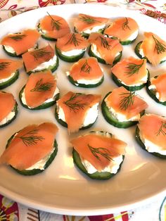 cucumbers with smoked salmon and dill on them are arranged on a platter