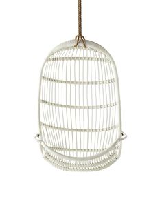 a white bird cage hanging from a rope