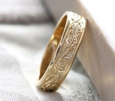 a gold wedding ring sitting on top of a white cloth