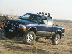 a pick up truck parked in the dirt