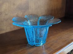 a blue glass vase sitting on top of a wooden table