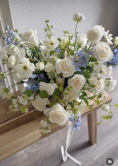 a bouquet of white and blue flowers on a bench