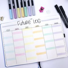 an open planner with pens and markers on it next to other items that include crayons