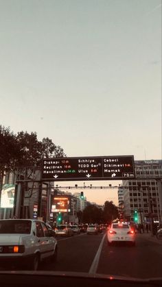 cars are driving down the street under an electronic sign