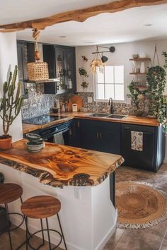 a kitchen with black cabinets and wooden counter tops, an island in the middle is surrounded by potted cacti