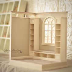 a doll house with furniture and shelves in the corner on top of a white bed