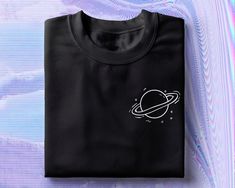 a black t - shirt with an image of the planet and saturn printed on it