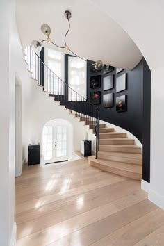 an empty room with stairs and pictures on the wall in it's centerpiece