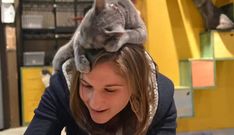 a woman with a cat on top of her head