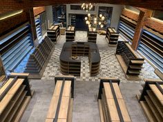 an overhead view of a restaurant with benches and tables in the center, looking down into the dining area