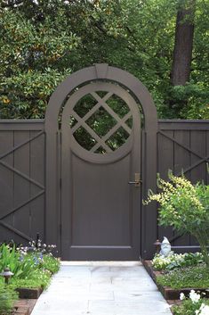 a wooden gate in the middle of a garden