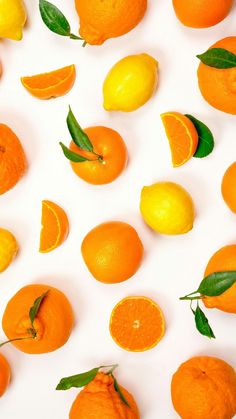 oranges and lemons are arranged on a white surface