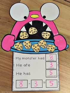 a pink monster is eating cookies out of a blue bowl with the number 3 on it