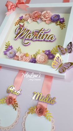 an open box with some flowers and butterflies on the inside is decorated with pink ribbon