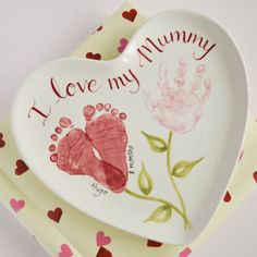 two heart shaped plates with handprints on them and the words i love my mommy