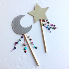 two stars and a crescent on sticks with beads