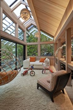 a living room filled with lots of furniture next to a large glass window covered wall