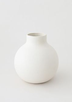 a white vase sitting on top of a table