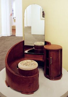 a vanity with stool and mirror in a room