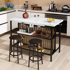 a kitchen island with two stools in front of it and bottles on the counter