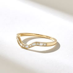 a gold ring with white stones on it