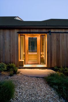 a wooden building with a lit up front door