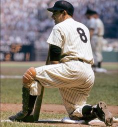 a baseball player sitting on the ground with his bat in hand and looking down at the ground