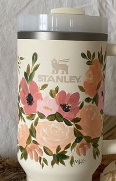 a coffee mug with flowers painted on it